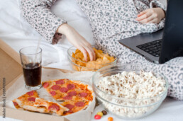 Beautiful young woman eating unhealthy food