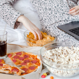 Beautiful young woman eating unhealthy food