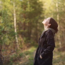 girl woman walking in nature park forest and breathing fresh air. concept of breathing, inhaling, relaxing