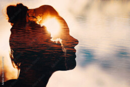 Sun peeks out from behind the clouds in woman's head.